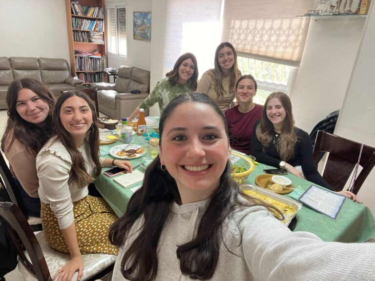 Group selfie of seven women at dinner table