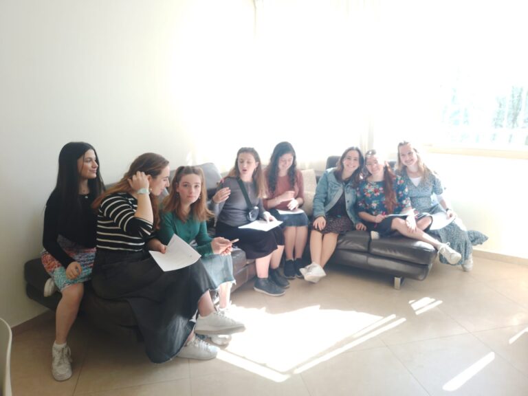 Group of women seated on couch with papers