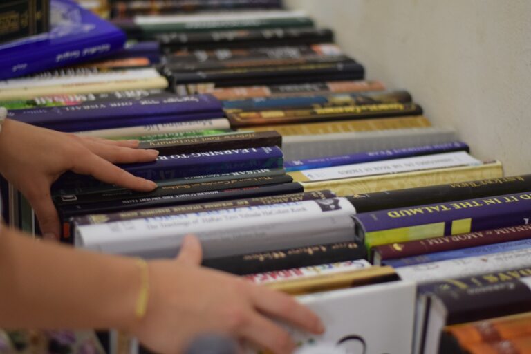 Hands browsing hardcover books on table