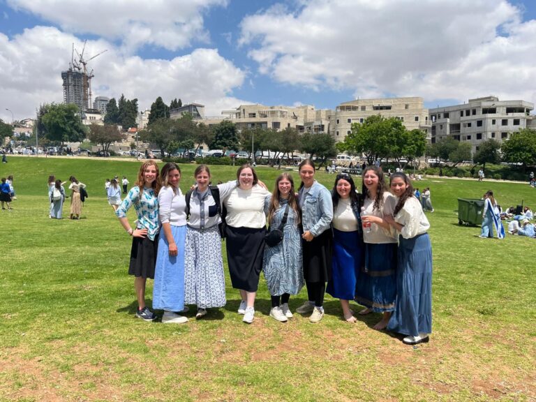 Group of women posing in grassy urban park