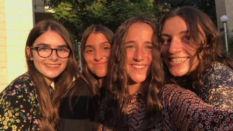 Four friends smiling in golden-hour selfie