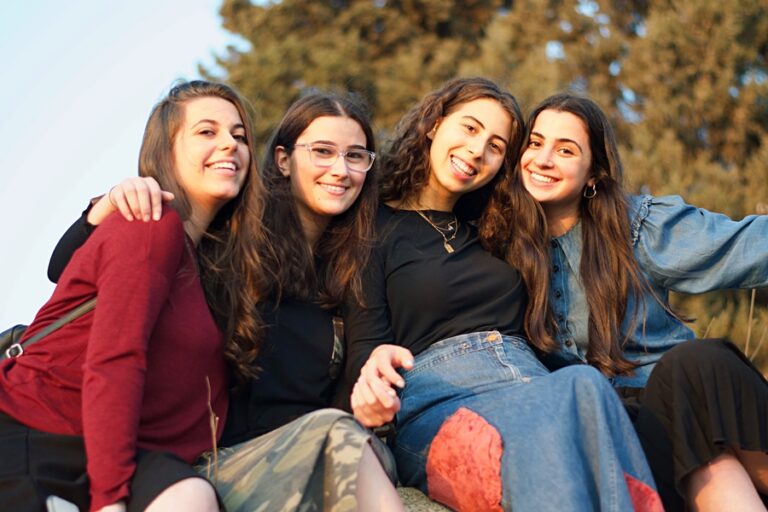 Four friends smiling together outdoors