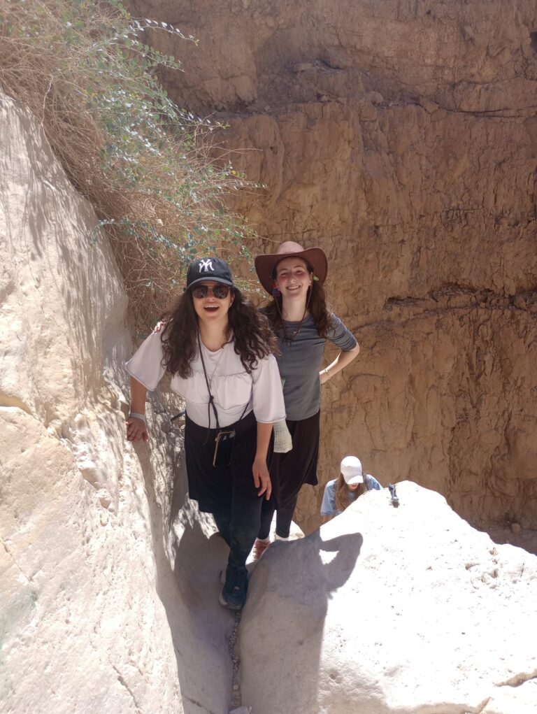 Two hikers smiling in narrow desert canyon
