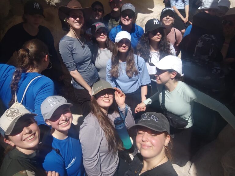 Group of smiling young women wearing caps