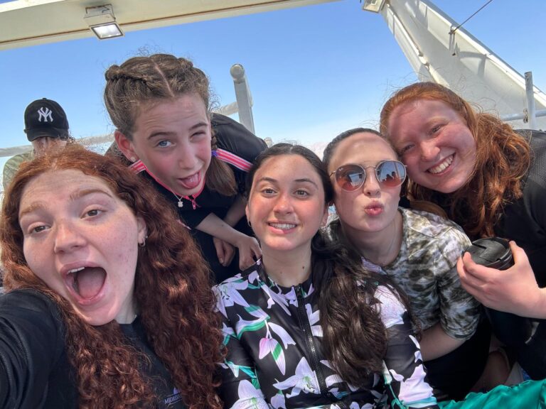 Five friends taking selfie on boat deck
