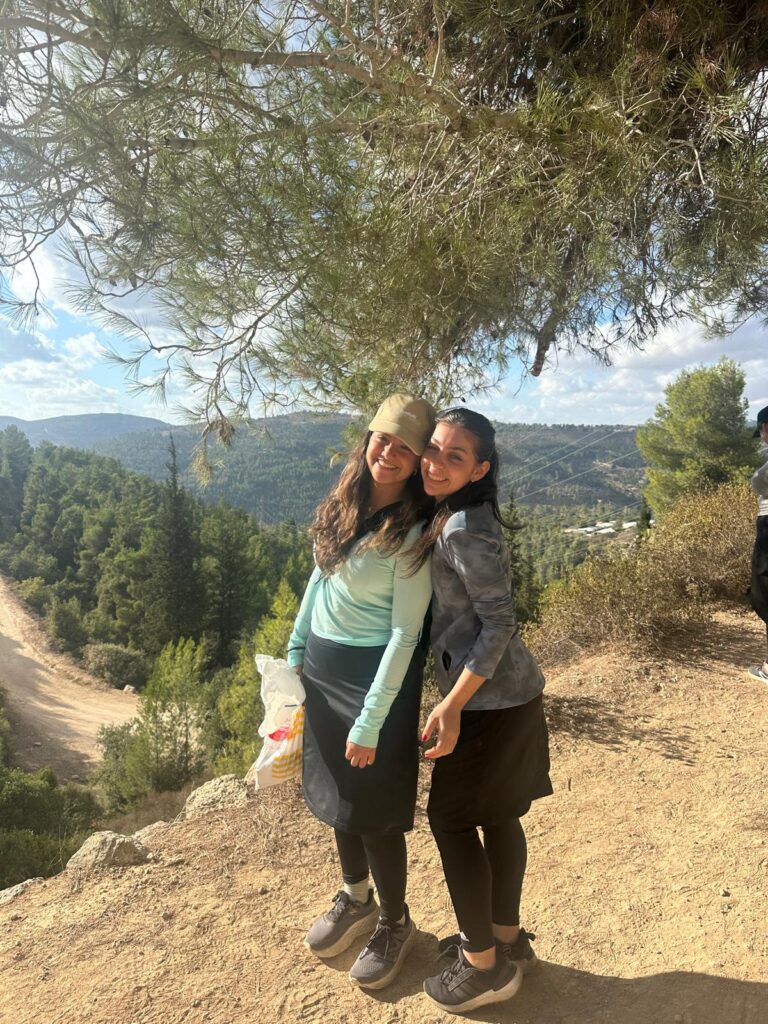 Two friends smiling on sunny hiking trail