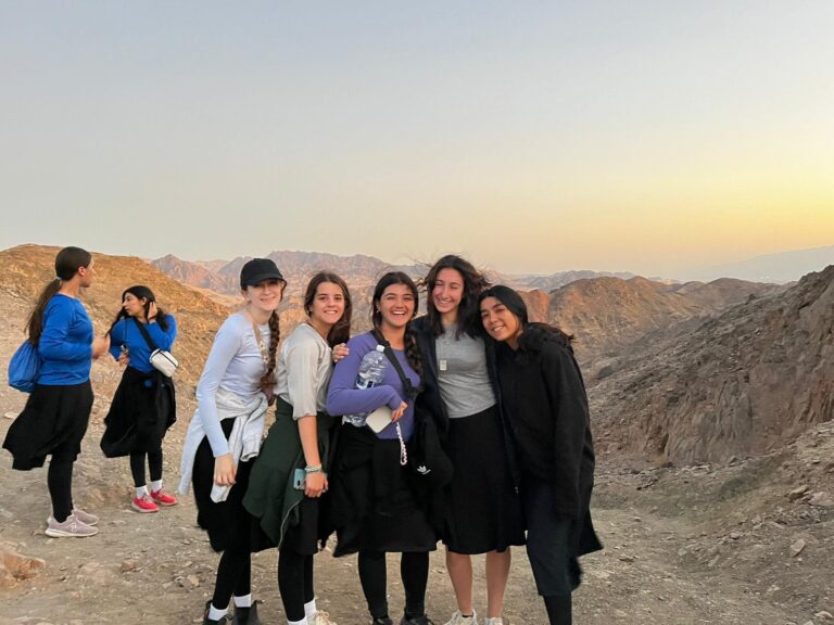 Smiling women hikers on rocky mountain trail