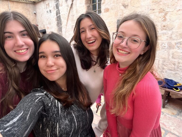 Friends laughing together by stone wall