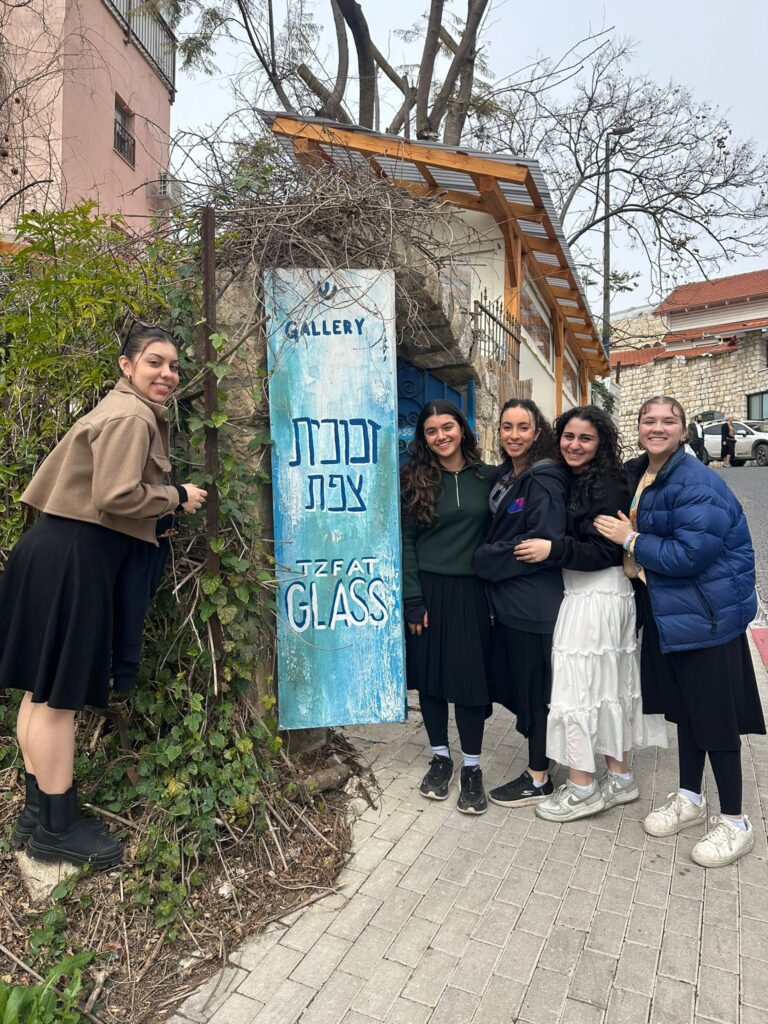 Five women posing by Tzfat Glass gallery sign