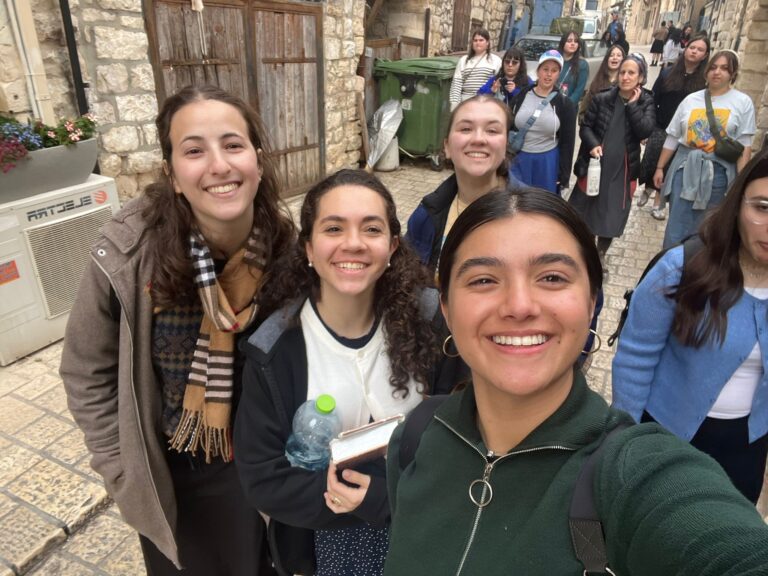 Smiling friends selfie on cobblestone street