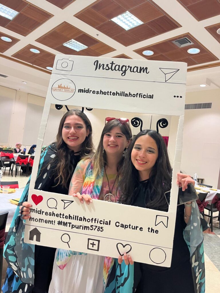 Three smiling women holding Instagram photo frame
