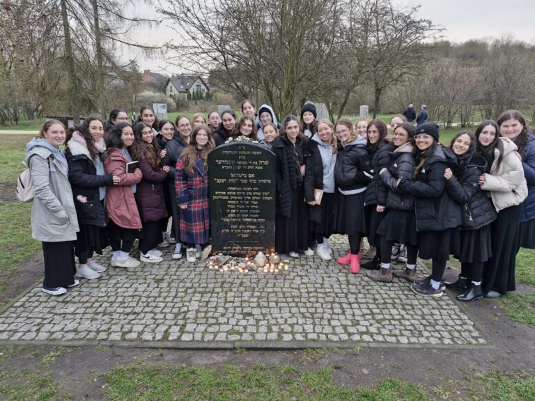 Young women around memorial stone with candles