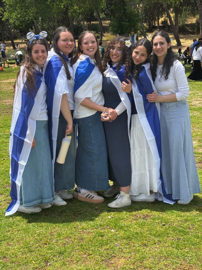 Six young women draped in Israeli flags