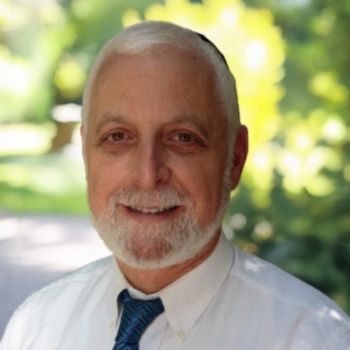 Bearded elderly gentleman smiling in sunlit park