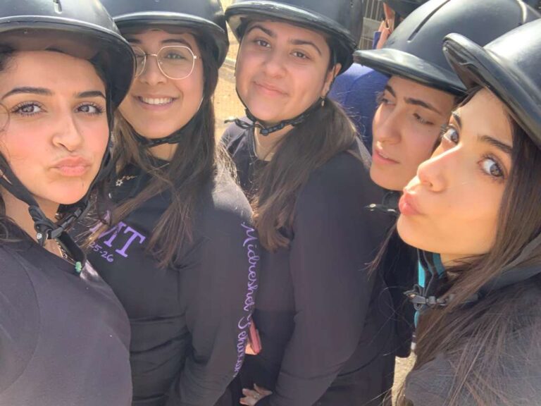 Five young women wearing helmets taking selfie