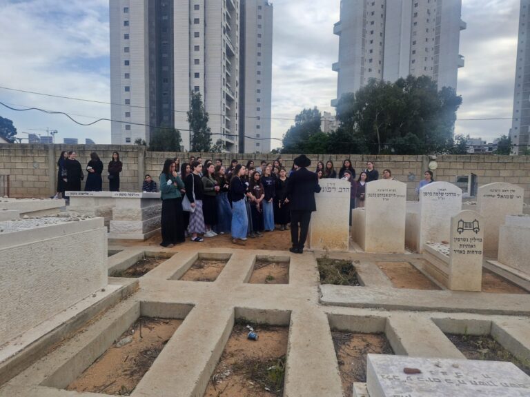 Group gathered among gravestones in urban cemetery